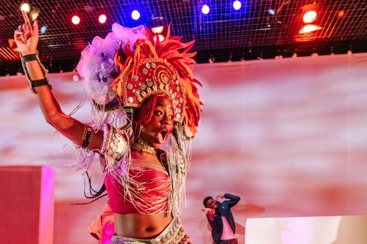 Actor wearing a large headdress on the set of Gone Too Far!